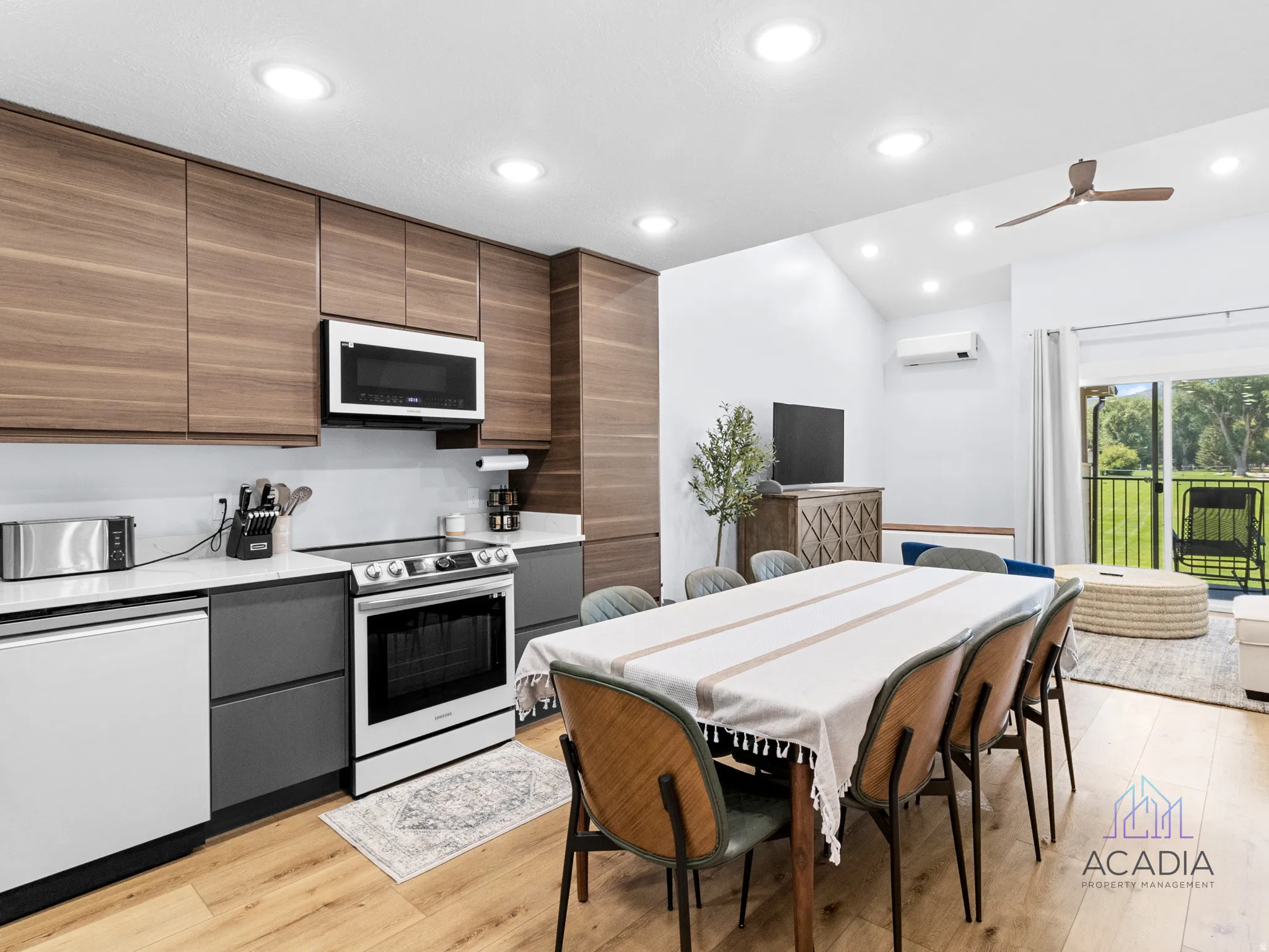 Modern kitchen with wood-finish cabinetry, white countertops, and stainless steel appliances