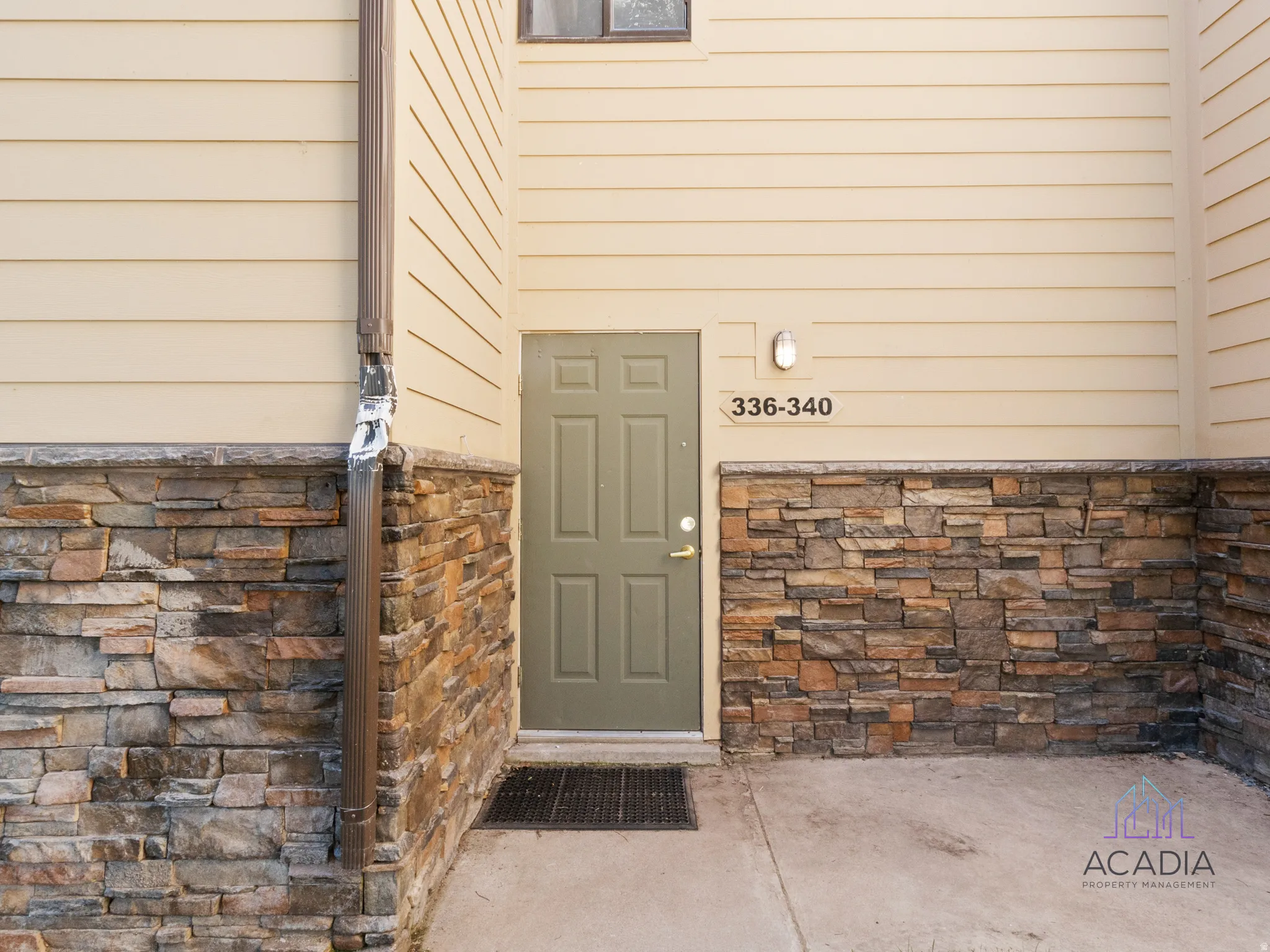 Exterior entry featuring stone veneer and horizontal siding