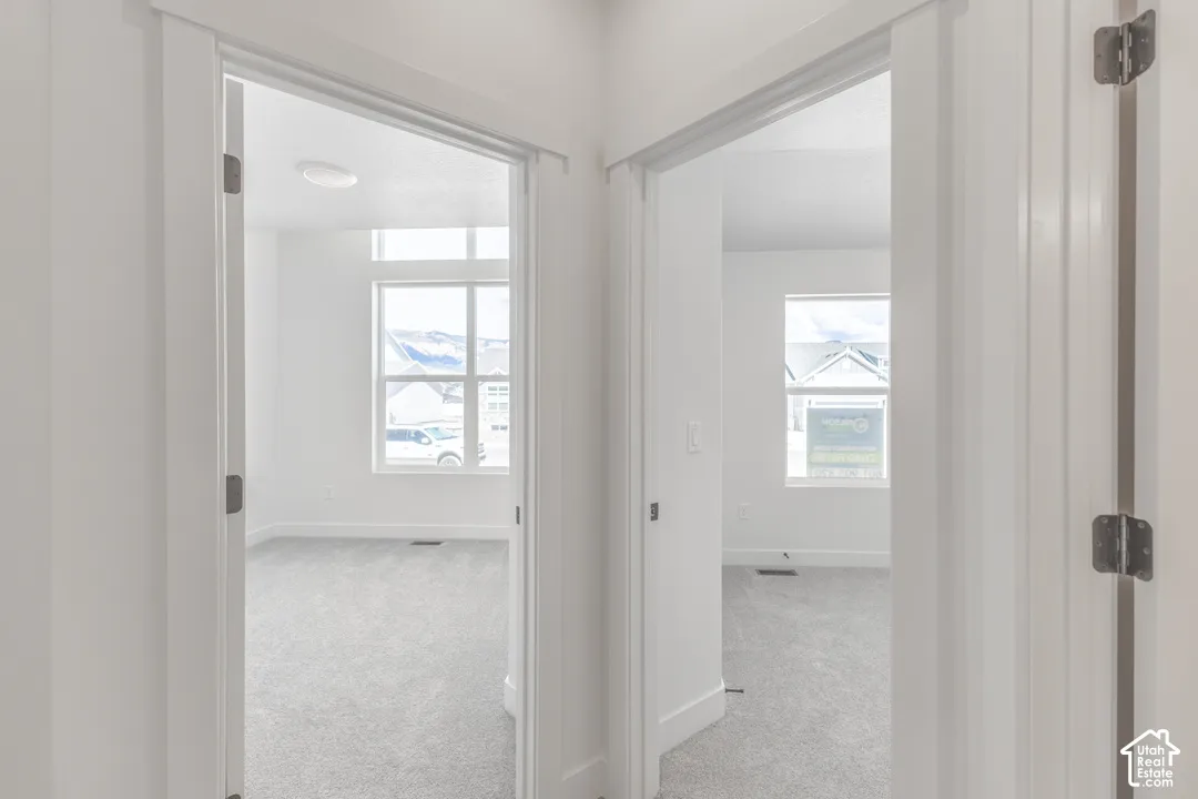 Two rooms featuring neutral-toned carpeting, white walls, and white trim