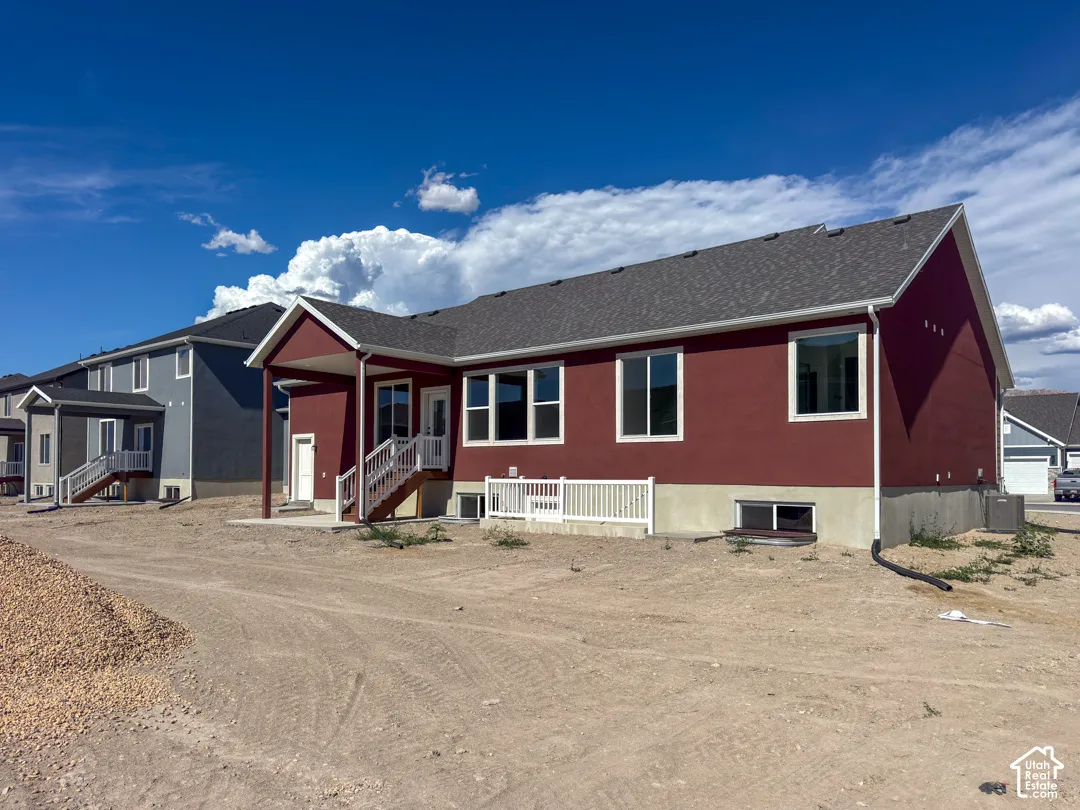 Red-hued exterior featuring multiple windows and a covered patio