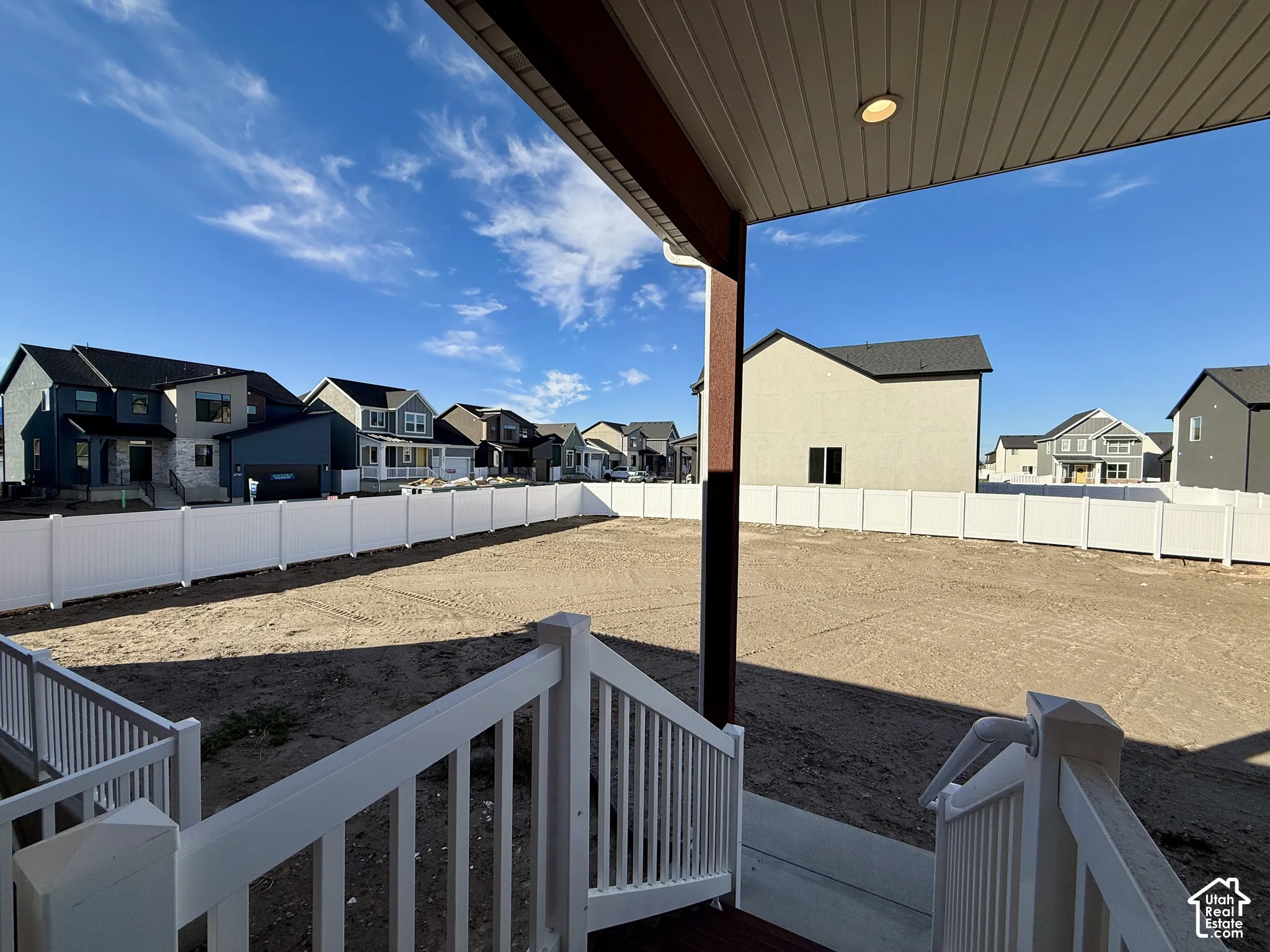 Covered rear patio featuring a vinyl railing system and recessed lighting, overlooking a fenced backyard