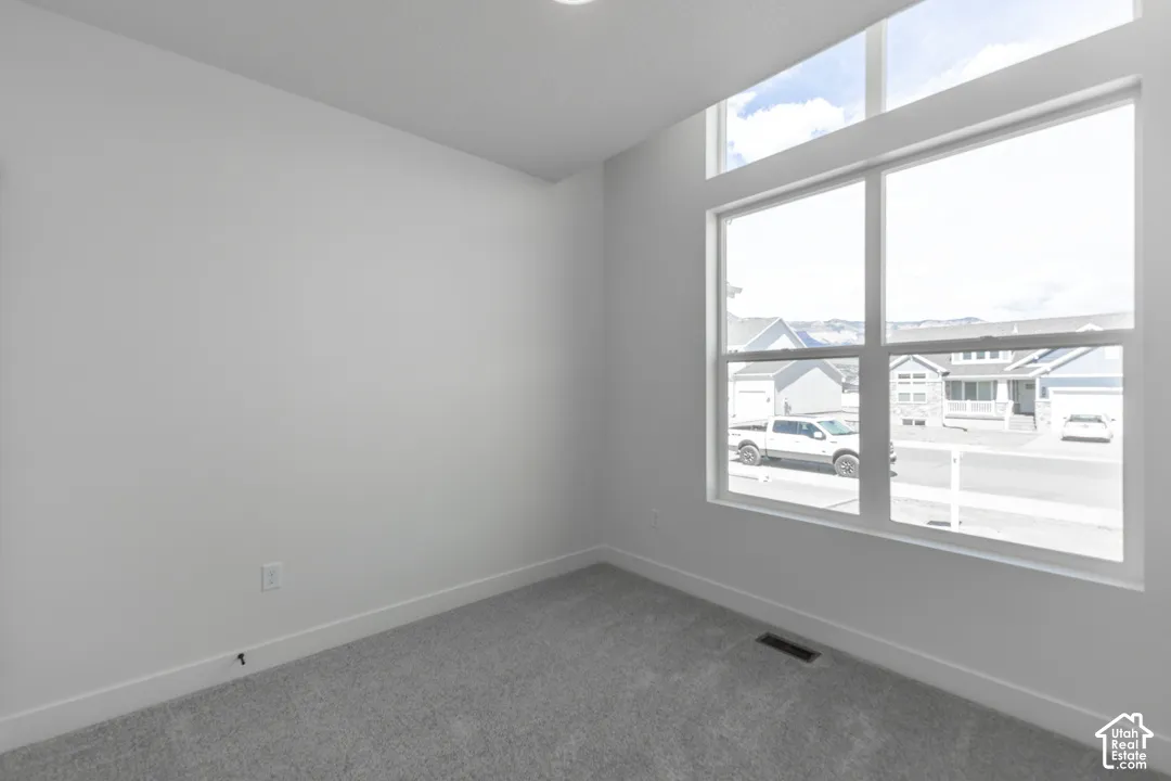 Room featuring high ceilings, light gray carpeting, and white walls