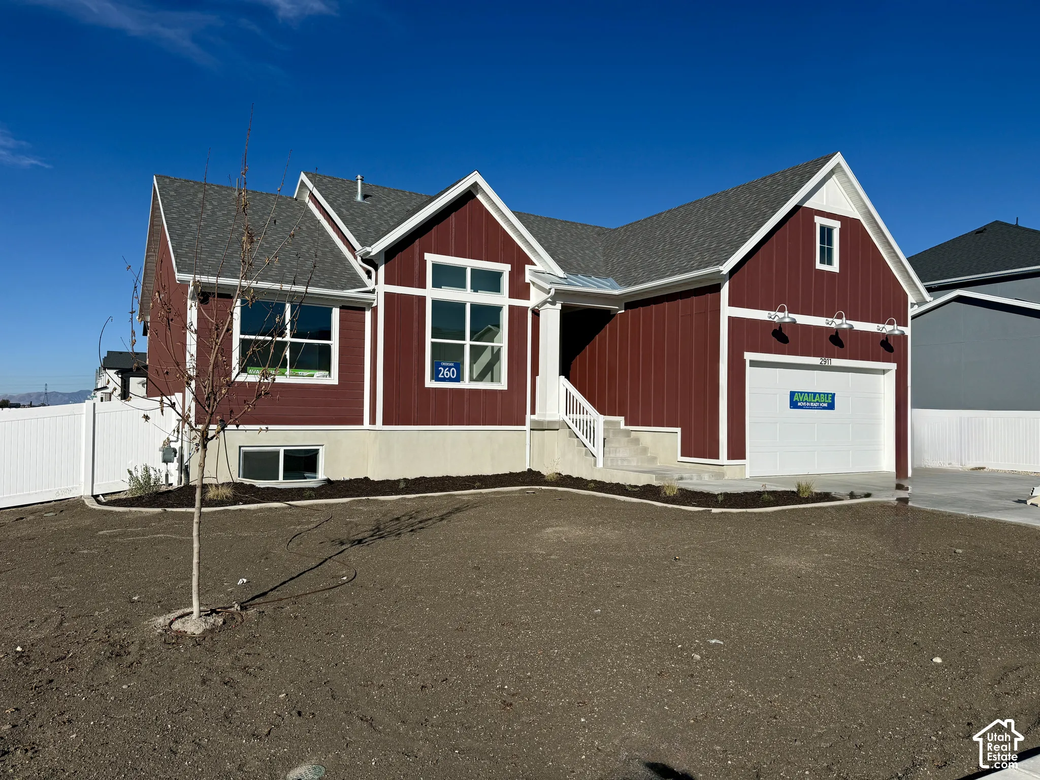 Craftsman-style exterior featuring vertical board-and-batten siding, a multi-gabled roofline, fixed-pane windows, a single-car garage, and a covered entry with a concrete staircase