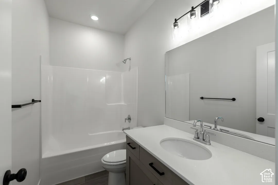 Bathroom featuring a single vanity with stone-look countertop, integrated sink, and wood-finish cabinetry