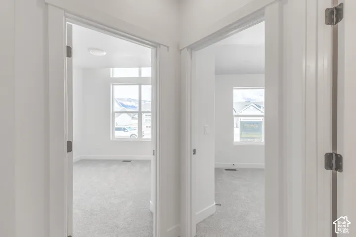 Two rooms featuring neutral-toned carpeting, white walls, and white trim