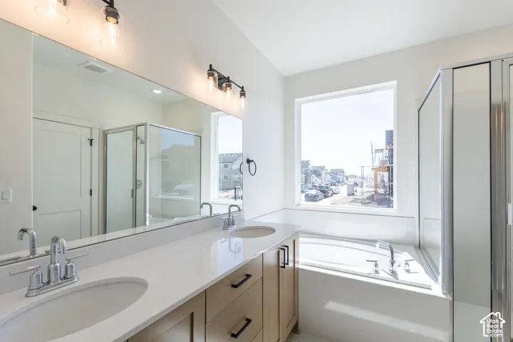 Dual vanity featuring light wood-finish cabinetry, white countertops, and undermount sinks