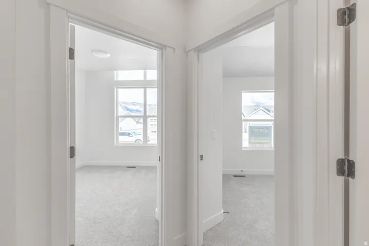 Two rooms featuring neutral-toned carpeting, white walls, and white trim