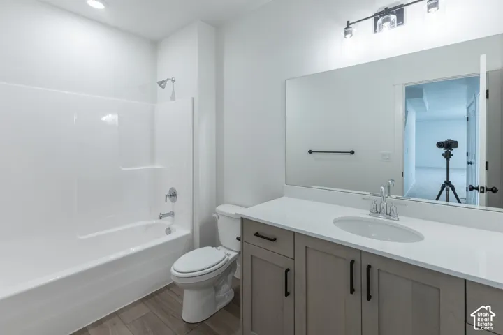 Bathroom featuring a single vanity with light-toned wood-finish cabinetry, a white countertop, and an undermount sink