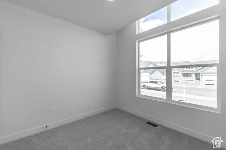 Room featuring high ceilings, light gray carpeting, and white walls