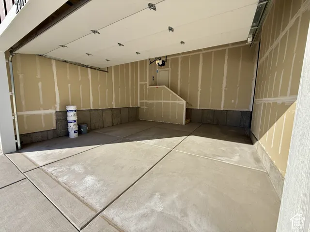 Multi-car garage featuring a concrete floor, sectional overhead door, and drywall-finished walls