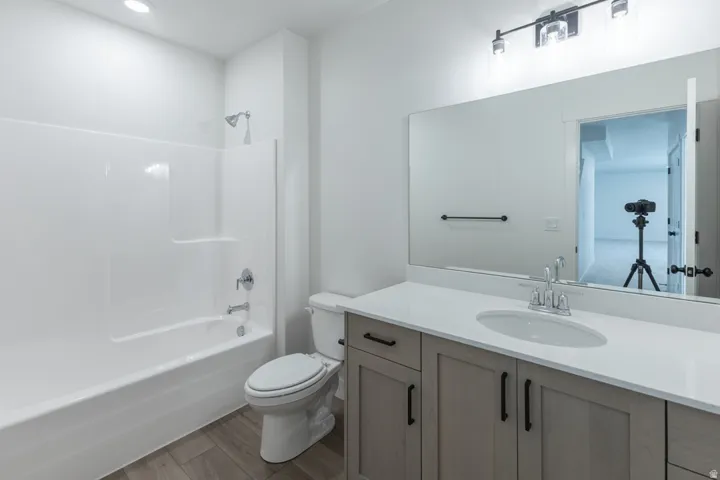 Bathroom featuring a single vanity with light-toned wood-finish cabinetry, a white countertop, and an undermount sink