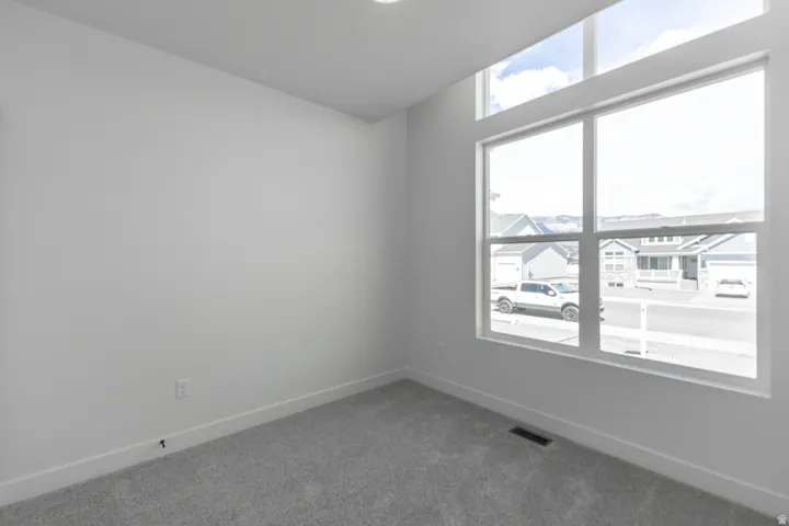 Room featuring high ceilings, light gray carpeting, and white walls