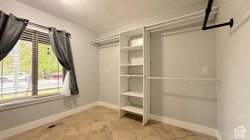 Laundry room featuring a built-in shelving and hanging rods.