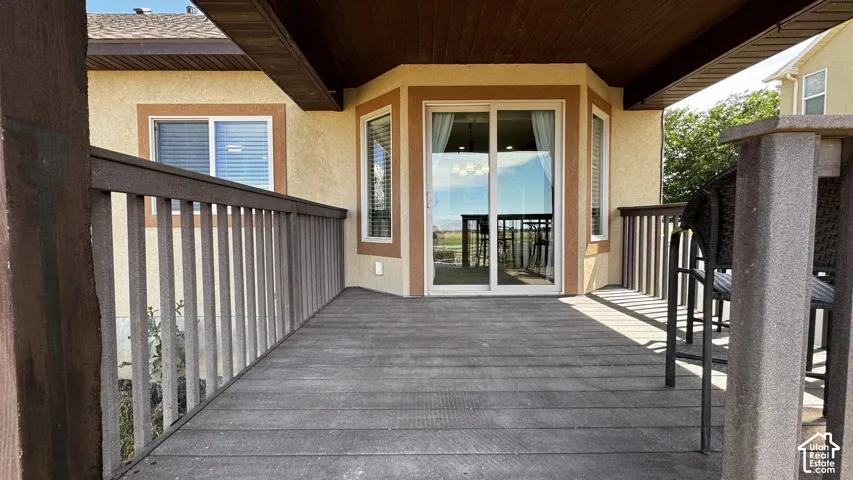 Spacious outdoor deck featuring composite decking, a dark brown railing, and a built-in bar area
