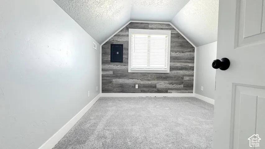 Bedroom with new carpet, wall Safe and closet. Neutral gray walls and white baseboards.