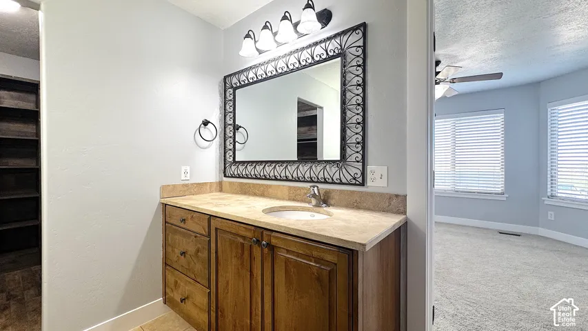 Primary bathroom vanity with a built-in sink, wood-finish cabinetry, and a granite countertops.