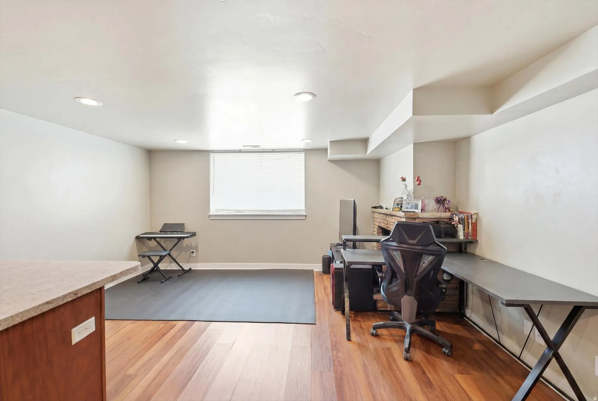 Open finished room with recessed lighting and a window featuring horizontal blinds