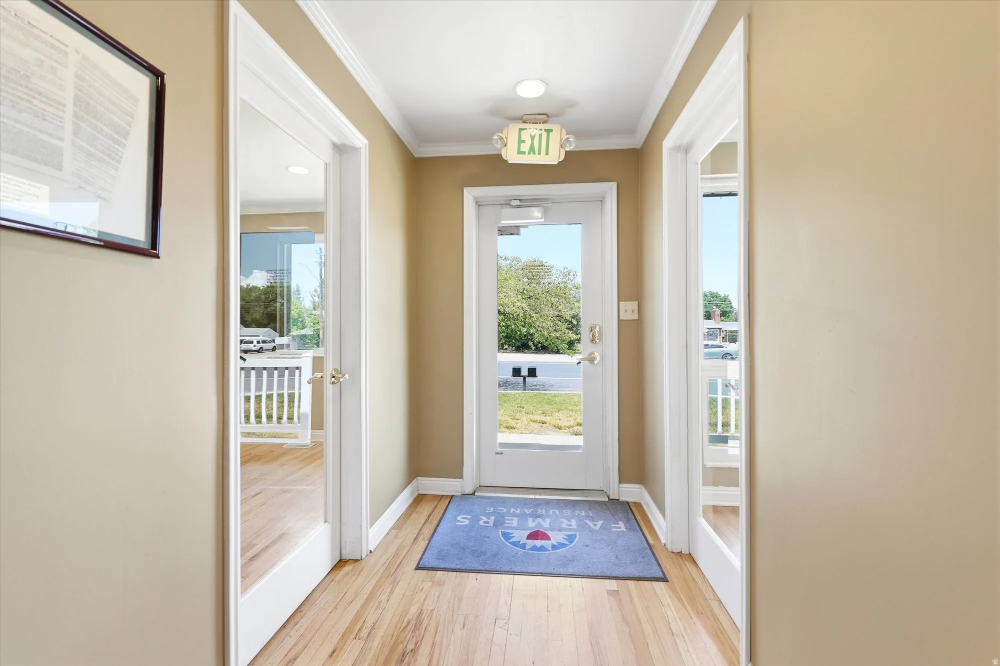Welcoming entry corridor featuring wood-finish flooring, neutral wall tones, and crown molding