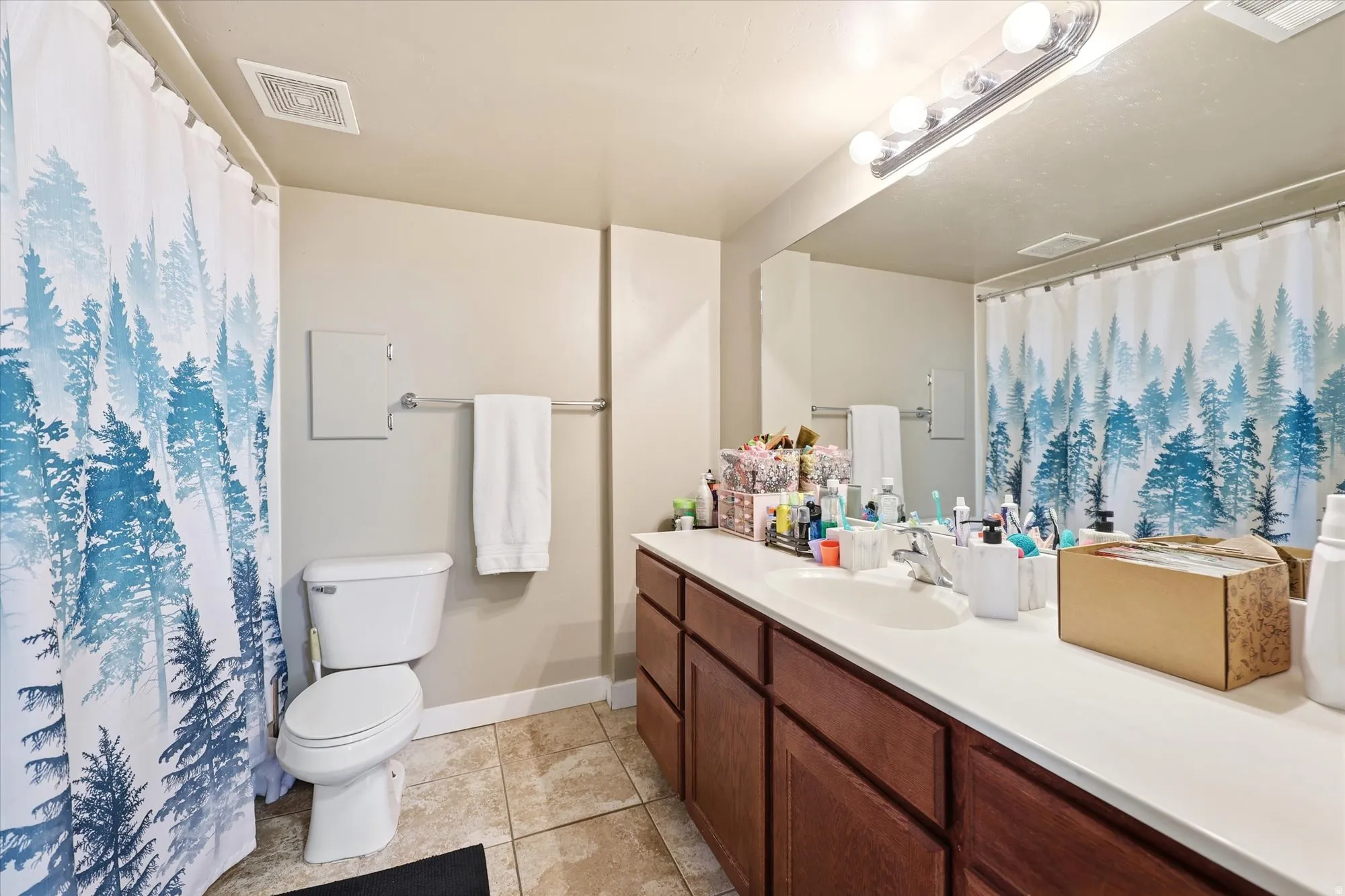 Bathroom featuring an extended vanity with wood-finish cabinetry and a white countertop