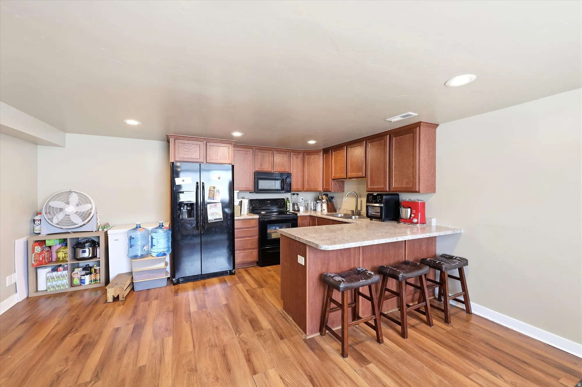 Kitchen featuring wood-finish flooring, recessed lighting, and a breakfast bar