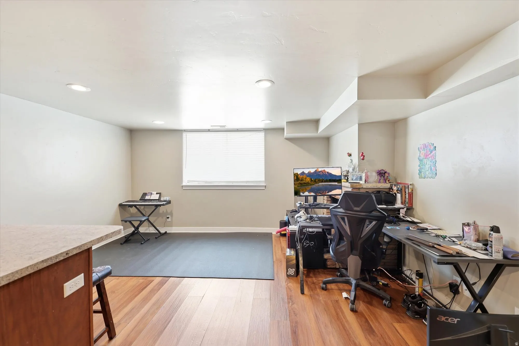 Spacious room featuring wood-finish flooring, recessed lighting, and a light beige wall color