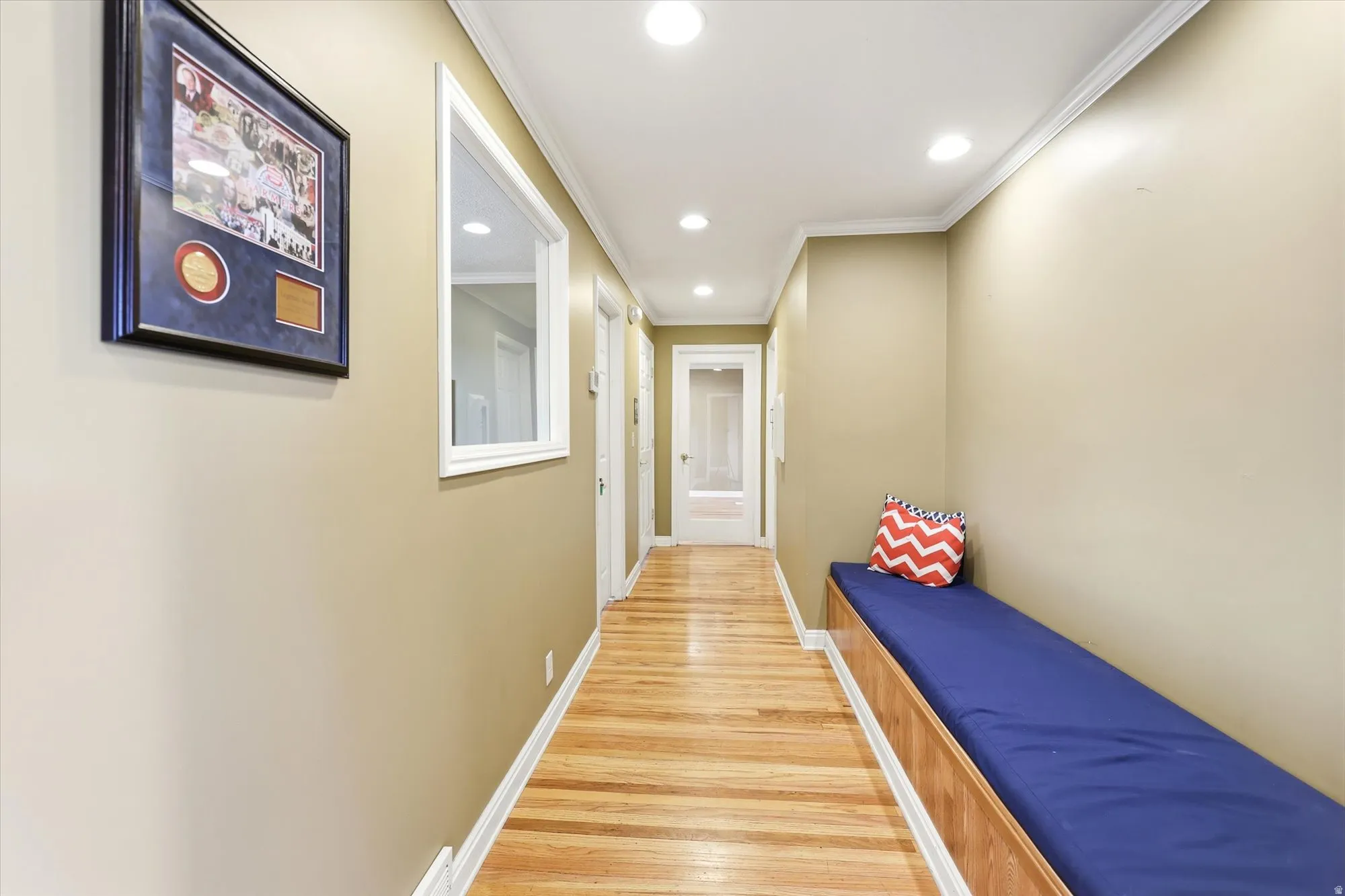 Hallway featuring wood-finish flooring, recessed lighting, and a built-in bench with storage