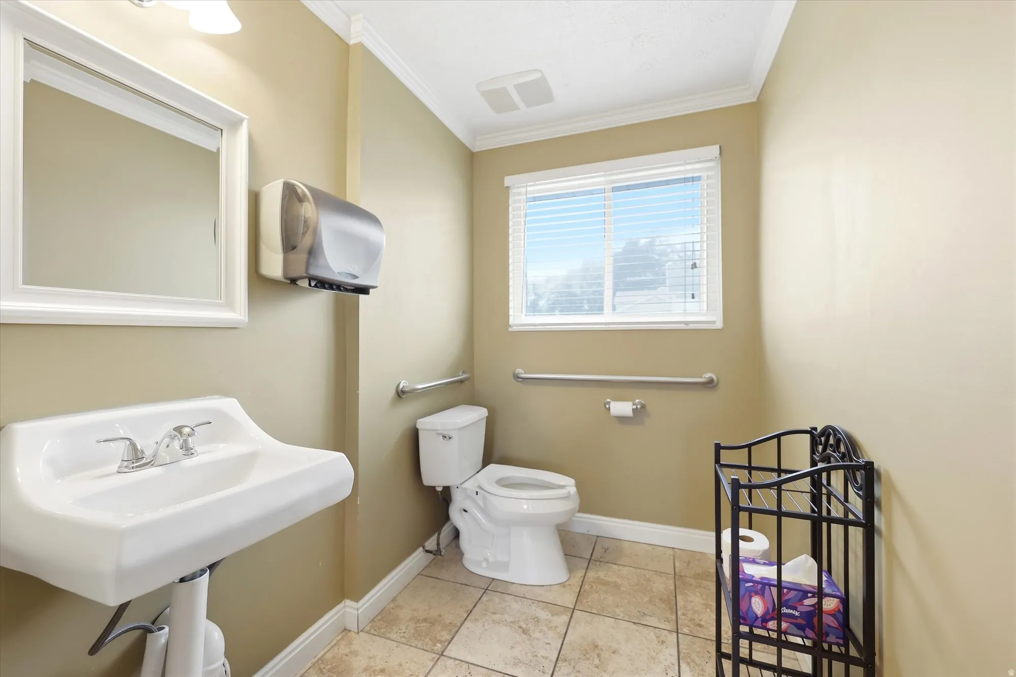 Bathroom featuring a pedestal sink, white framed mirror, and a window with blinds