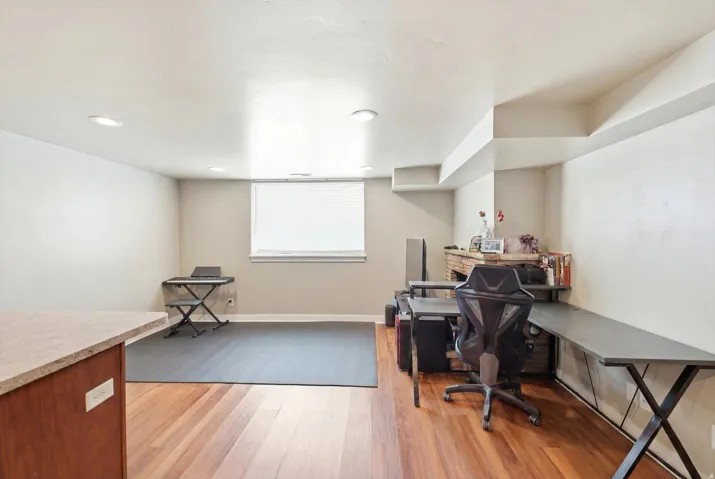 Open finished room with recessed lighting and a window featuring horizontal blinds