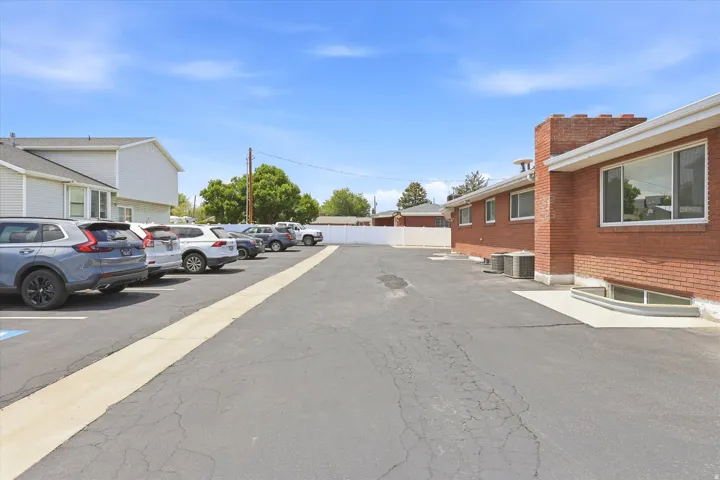 Expansive paved parking lot featuring marked spaces and a white perimeter fence
