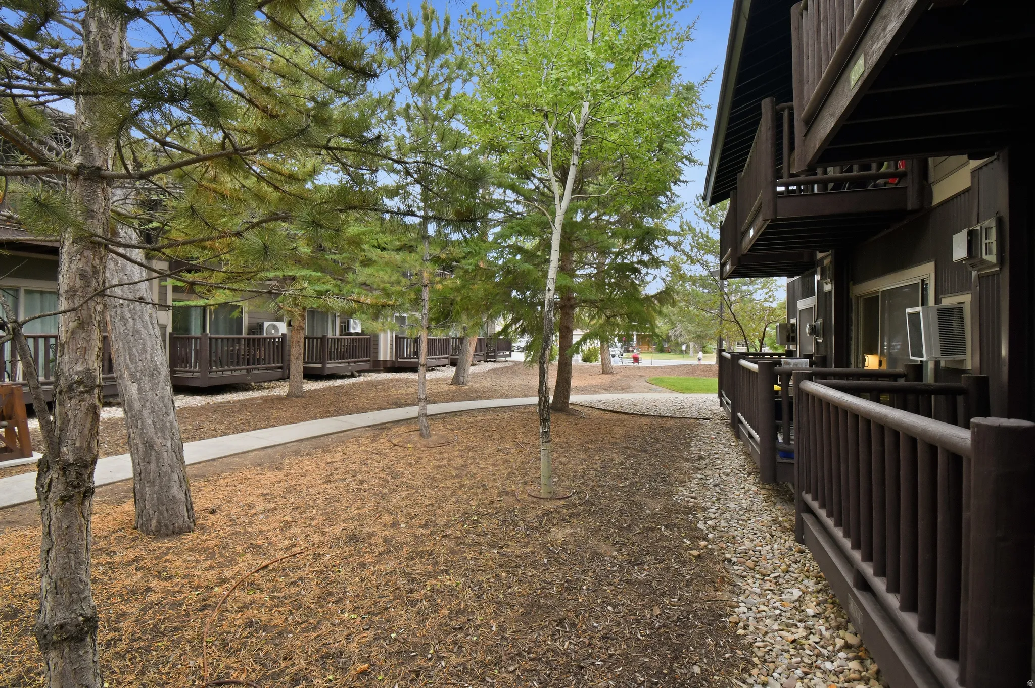 Brown-painted exterior with multiple private balconies and ground-level patios