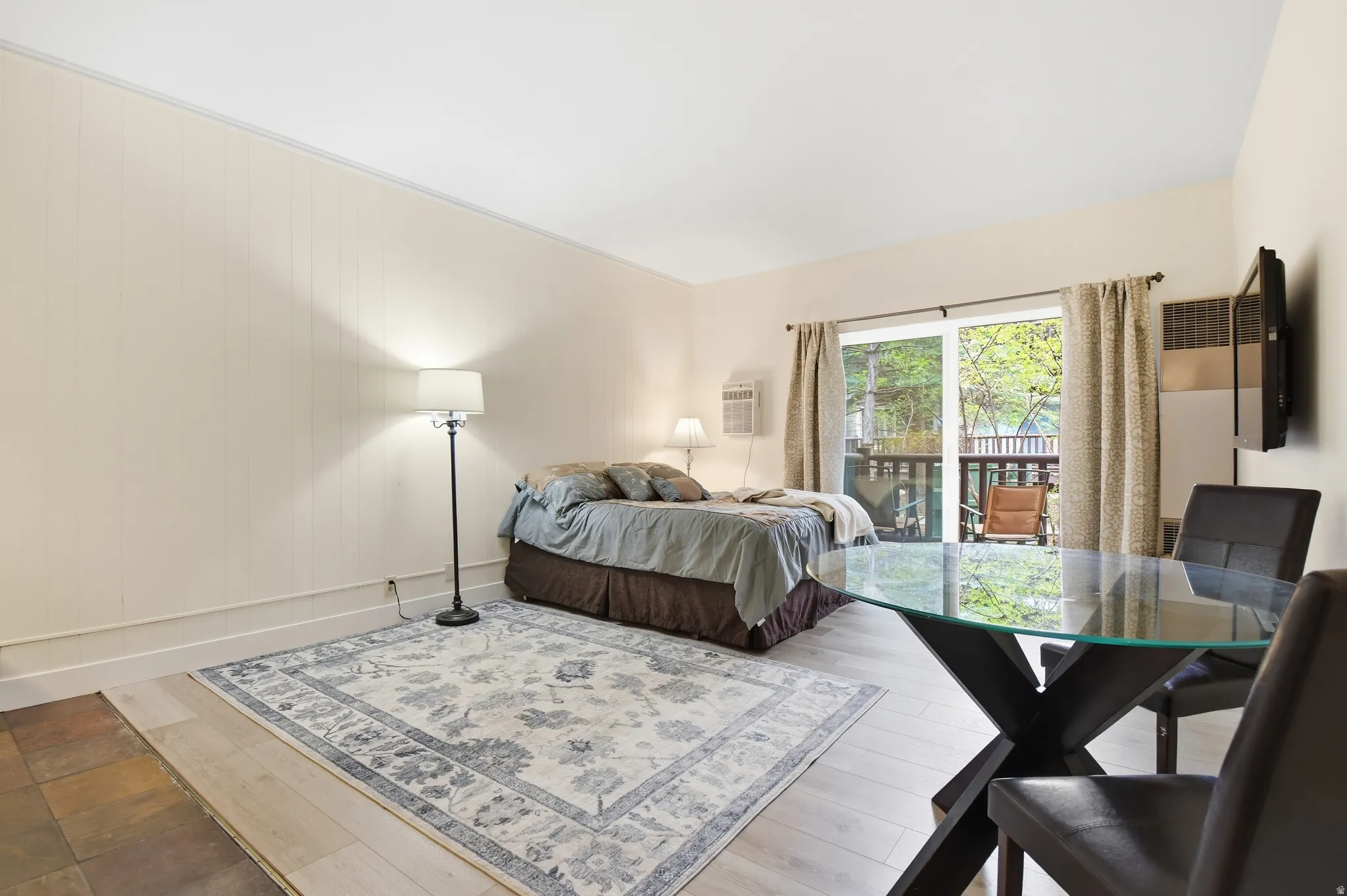 Light-toned interior with mixed flooring including wood-finish planks and stone-look tiles
