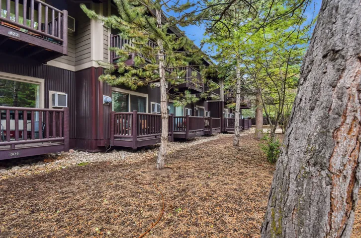 Ground-level patios and upper-level balconies featuring dark wood railings