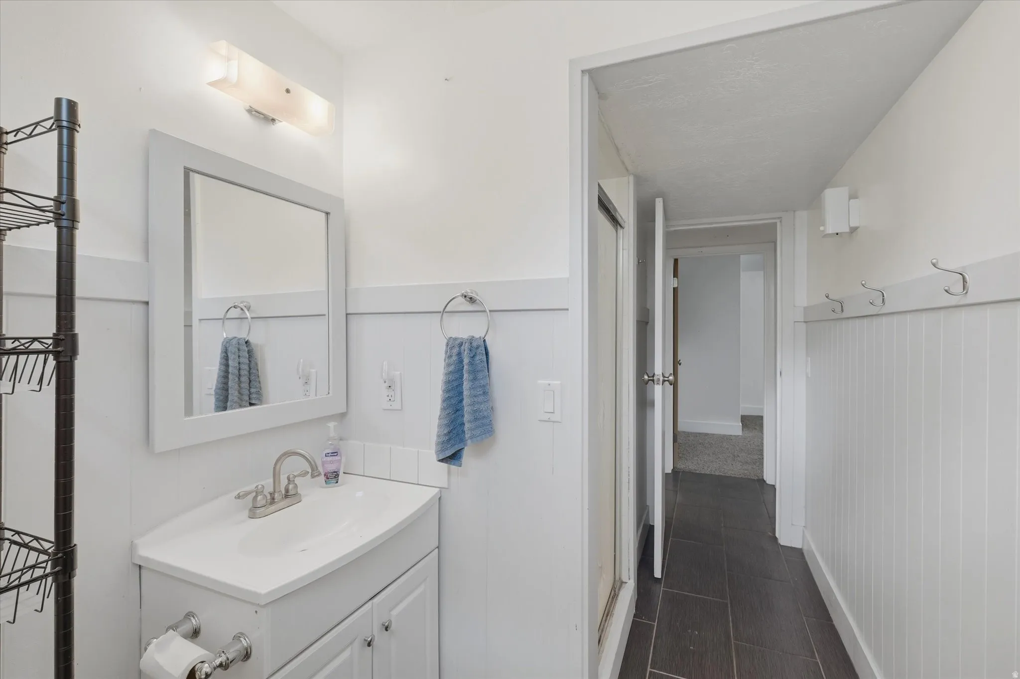 Bathroom featuring a white vanity with a single basin, brushed nickel faucet, and framed mirror