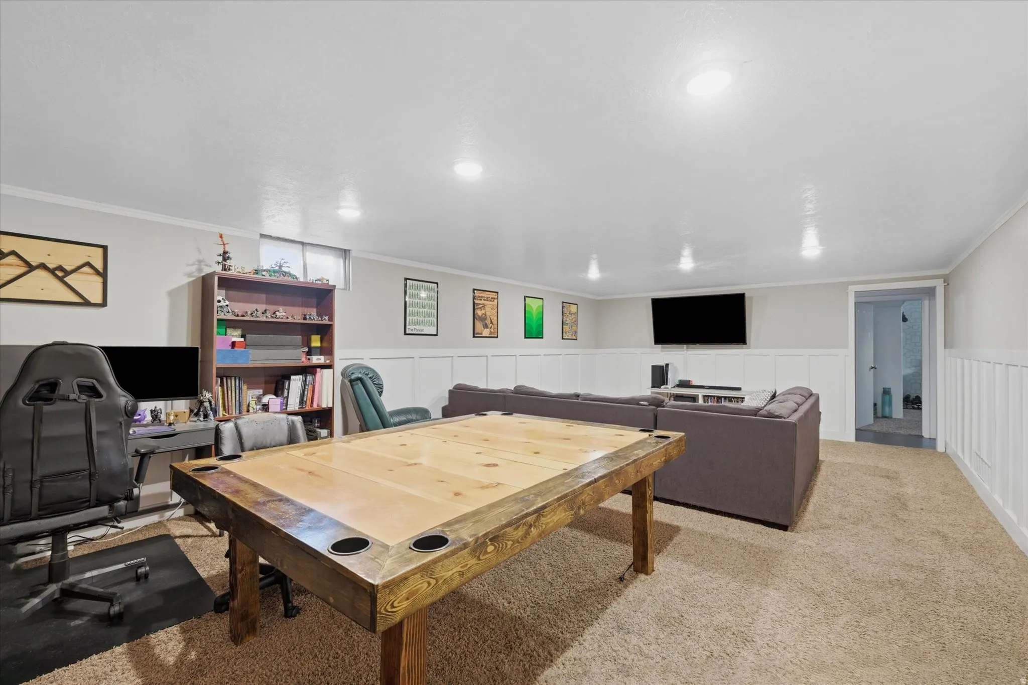 Finished recreation room featuring recessed lighting, carpeting, wainscoting, and a built-in bookshelf