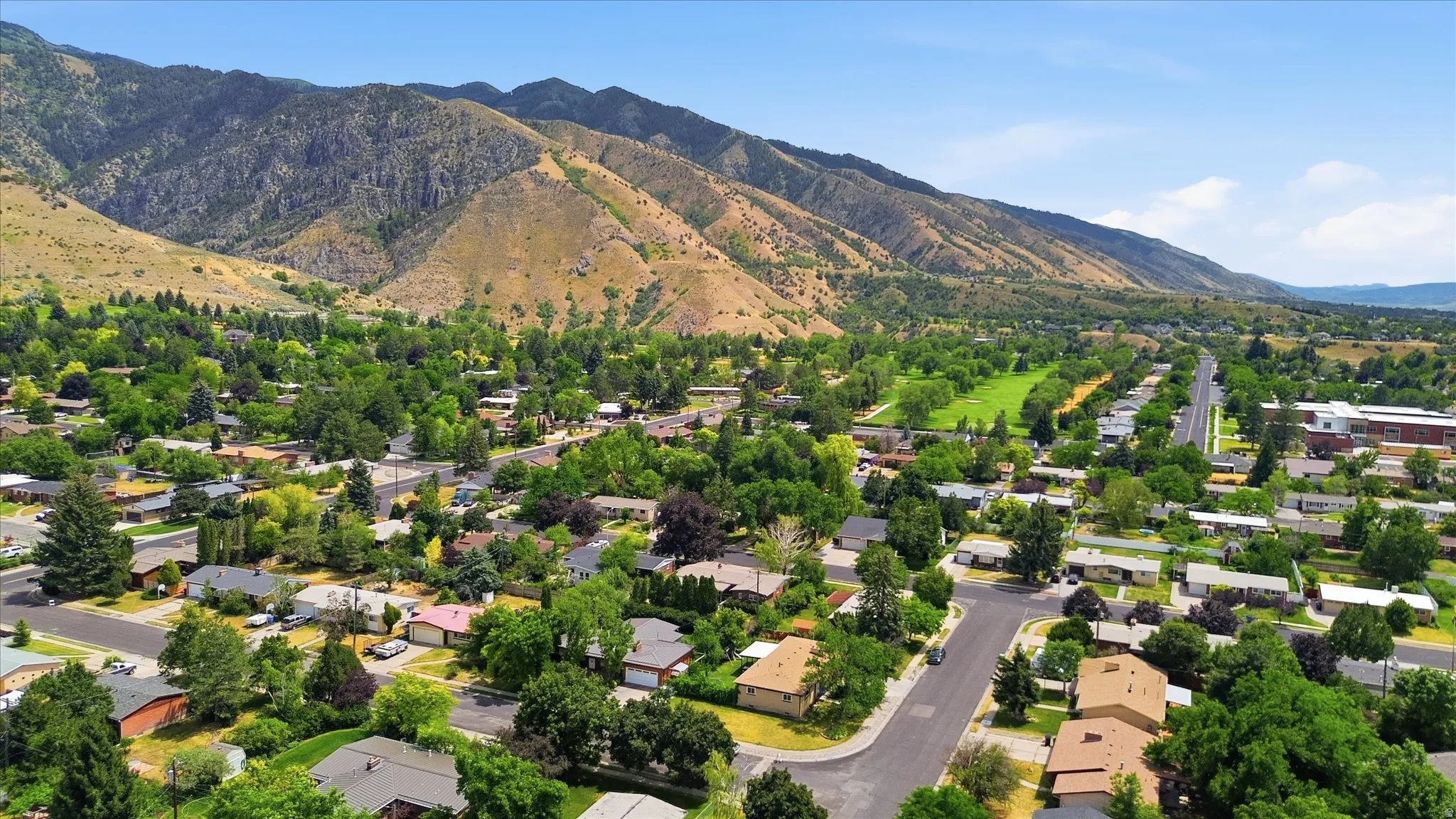Expansive suburban landscape framed by distant mountains and a clear sky