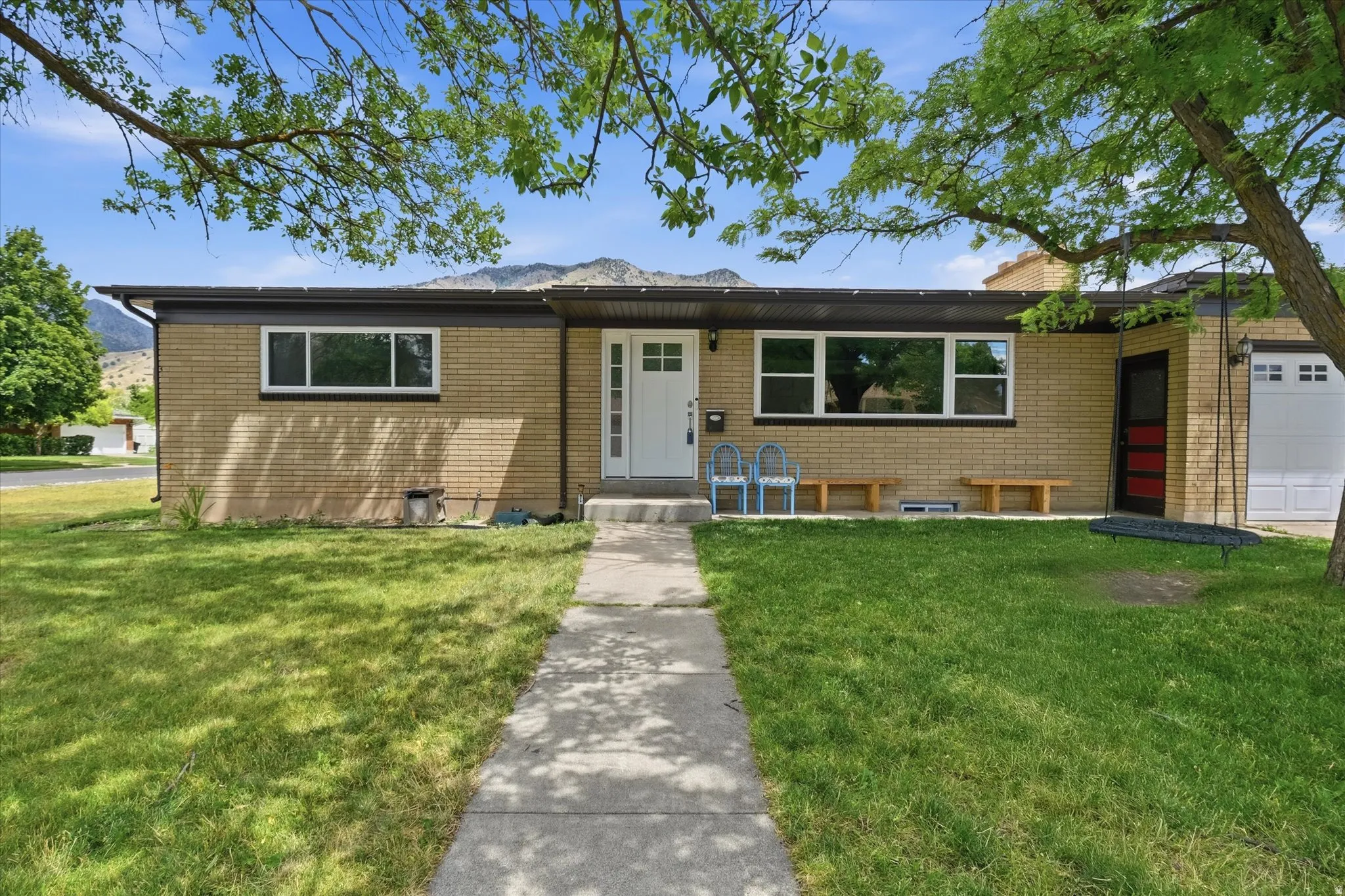 Brick exterior with a white entry door, an integrated garage, and a concrete pathway leading to the entrance