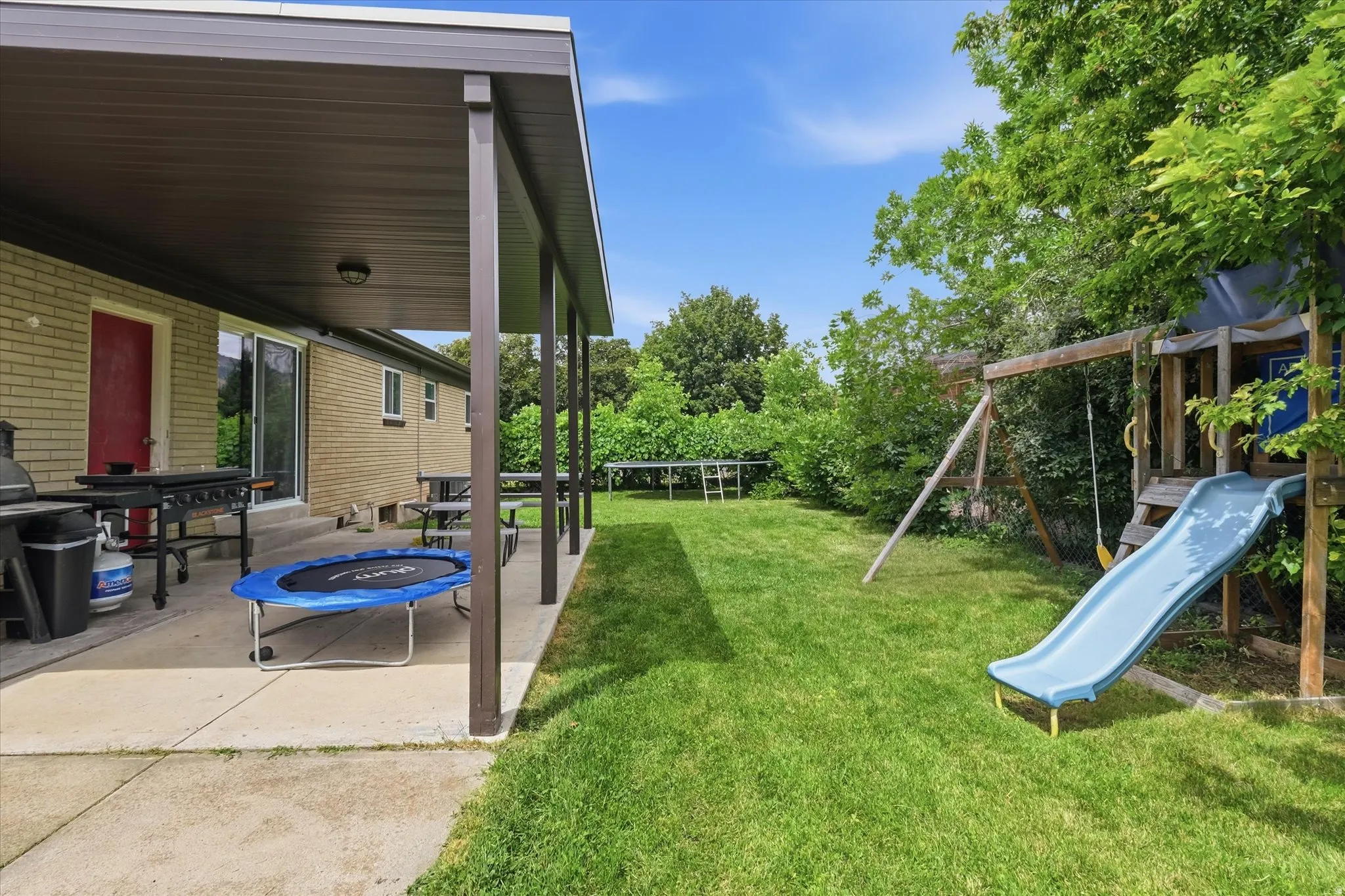 Expansive green lawn with mature perimeter foliage