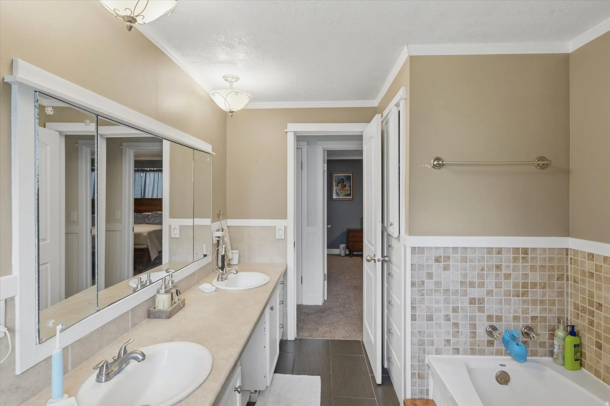 Dual vanity with integrated sinks and extensive counter space, complemented by a large mirrored medicine cabinet