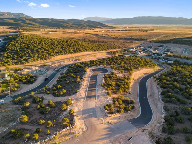 Developing residential community featuring paved roads, scattered mature greenery, and mountain scenery