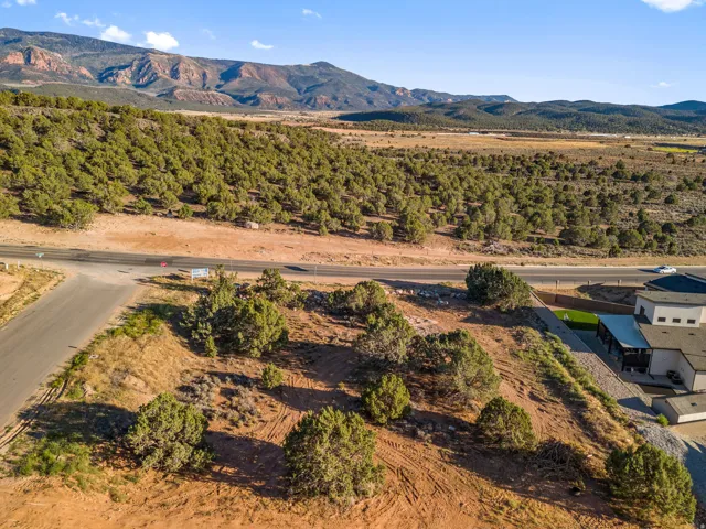 Expansive lot featuring natural desert vegetation, a paved road frontage, and distant mountain backdrops