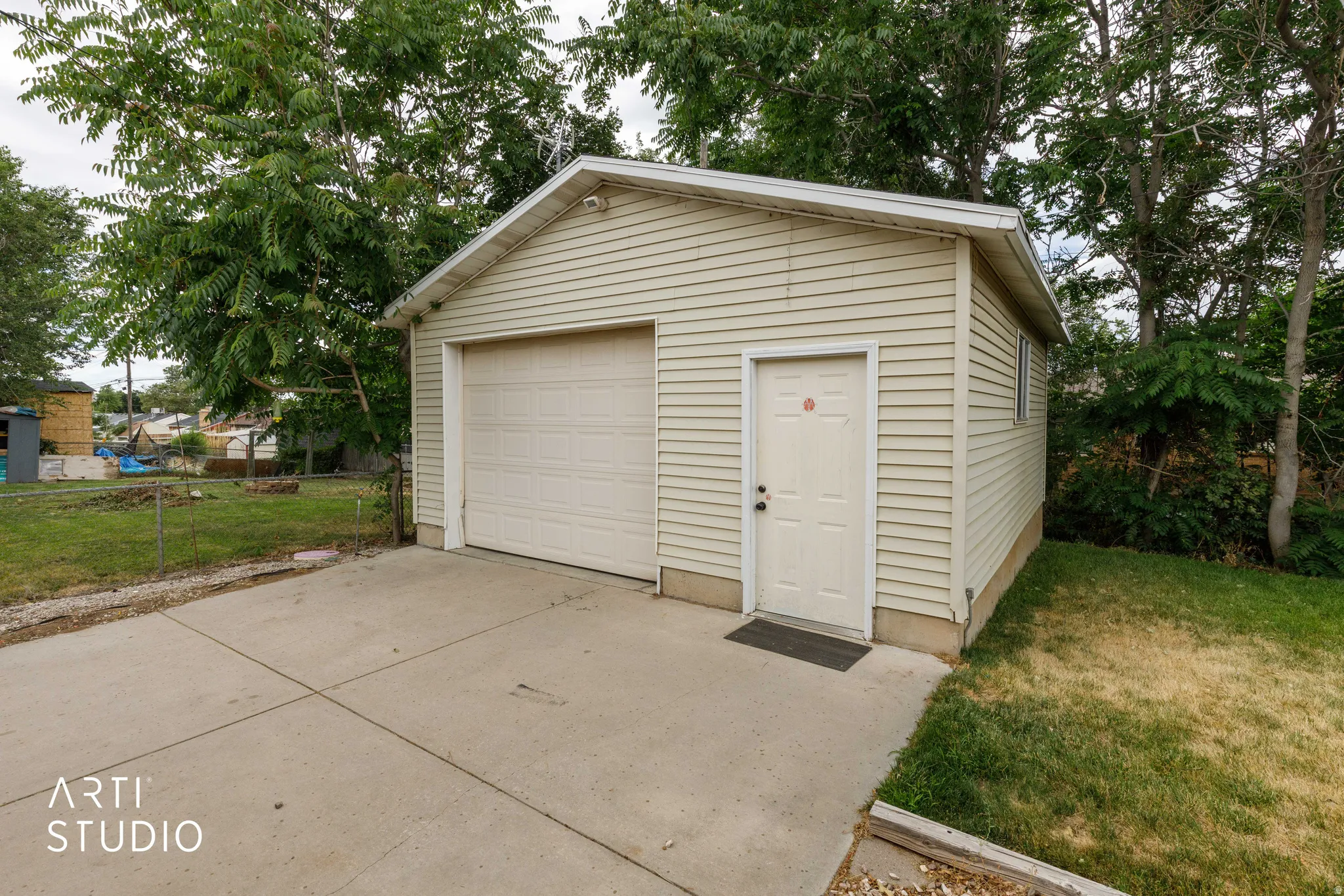 Detached single-car garage featuring horizontal siding and a panel-style door