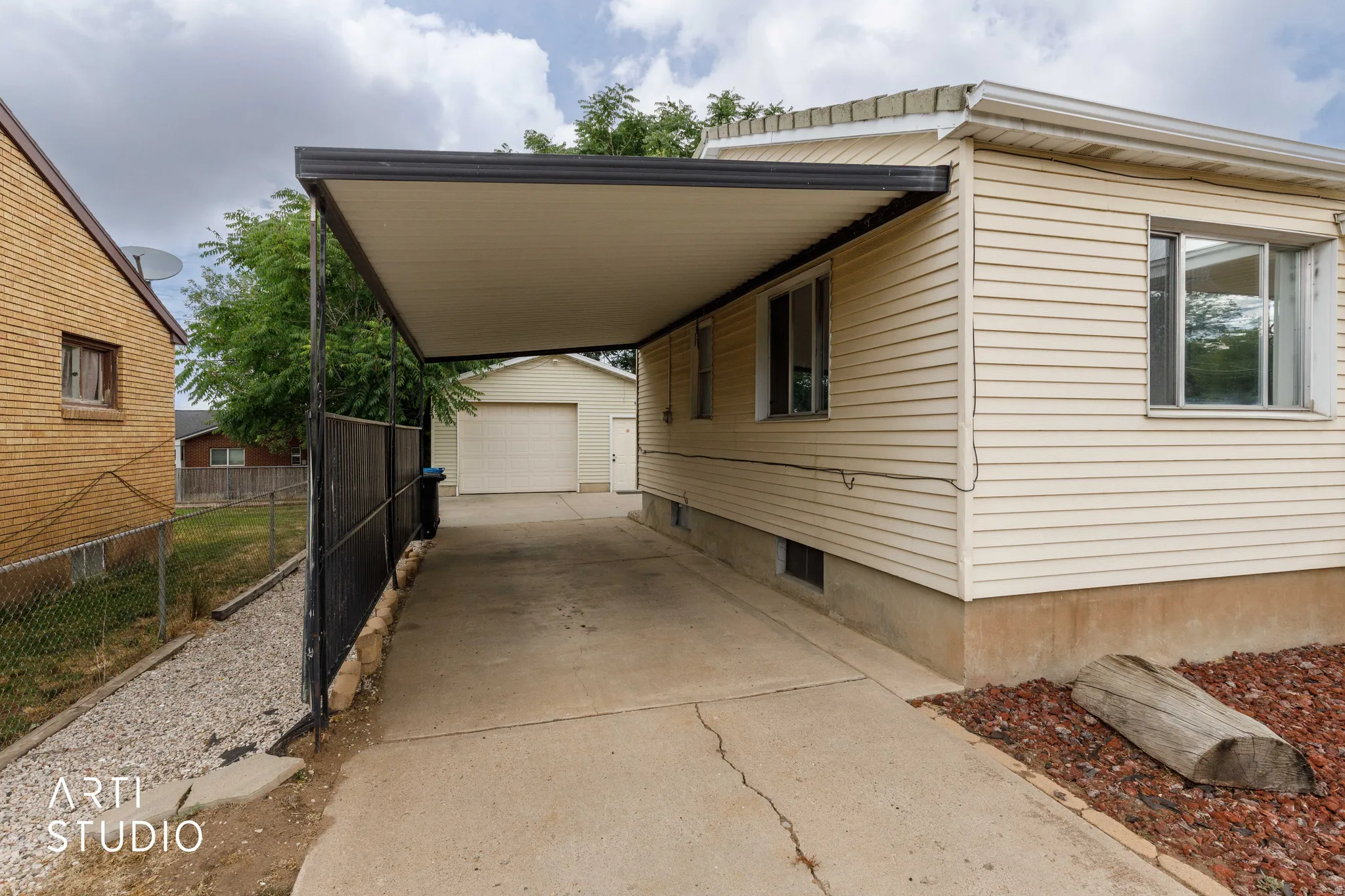 Covered carport extending to a detached garage