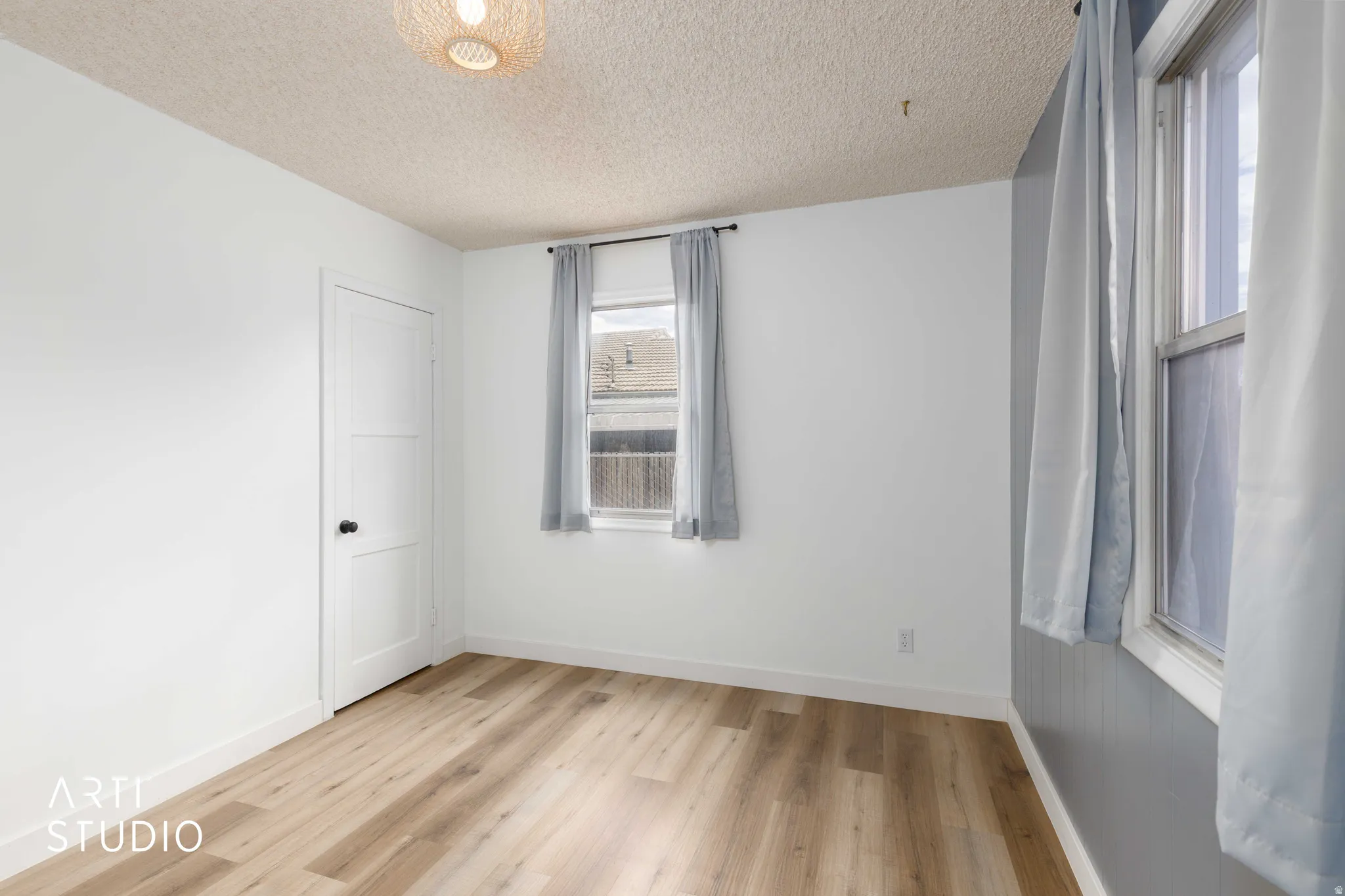 Light wood-finish flooring complements white walls with matching trim