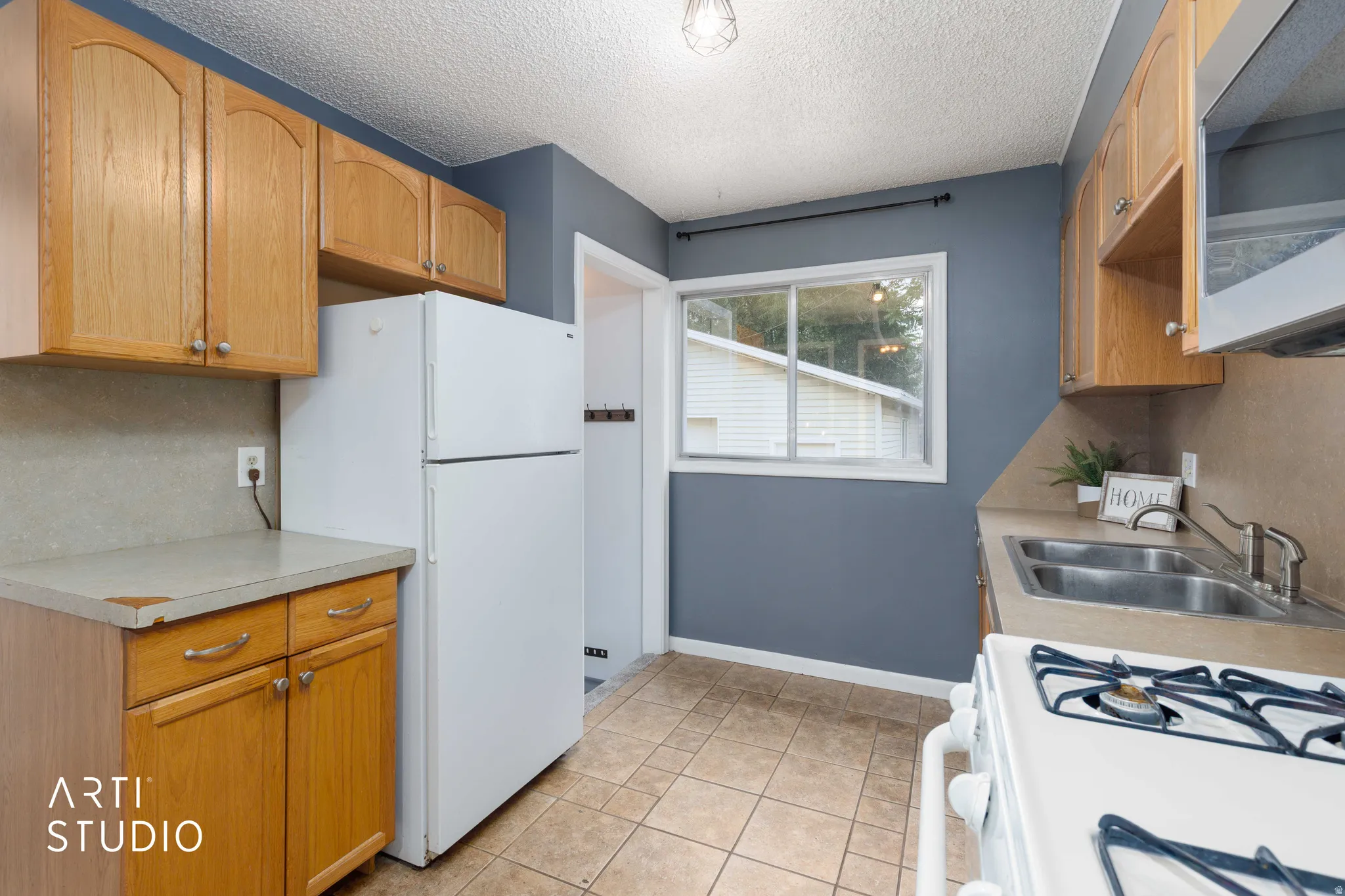 Kitchen featuring wood cabinetry, tile flooring, and a double basin sink