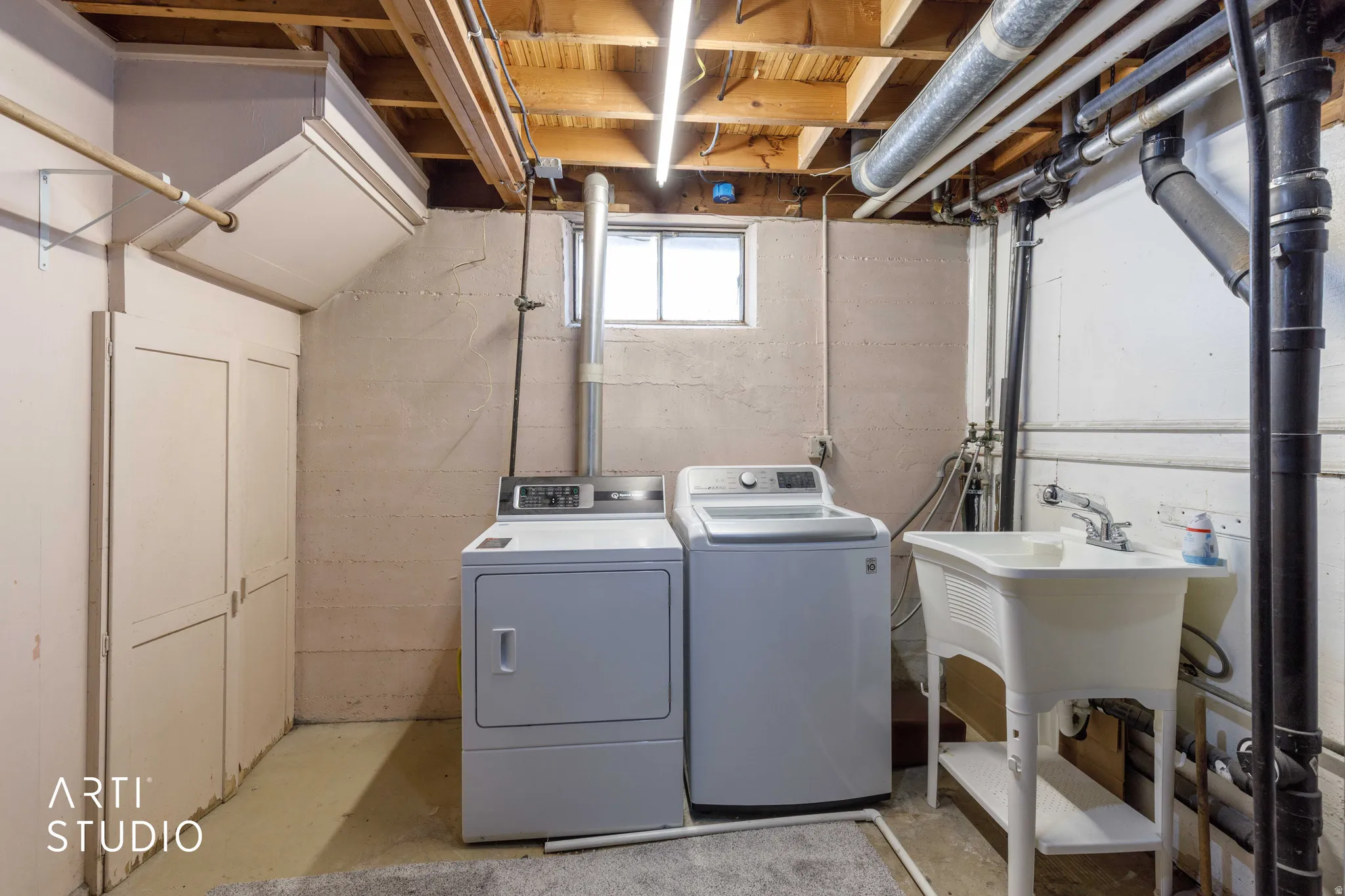Dedicated laundry area featuring a utility sink, washer, and dryer