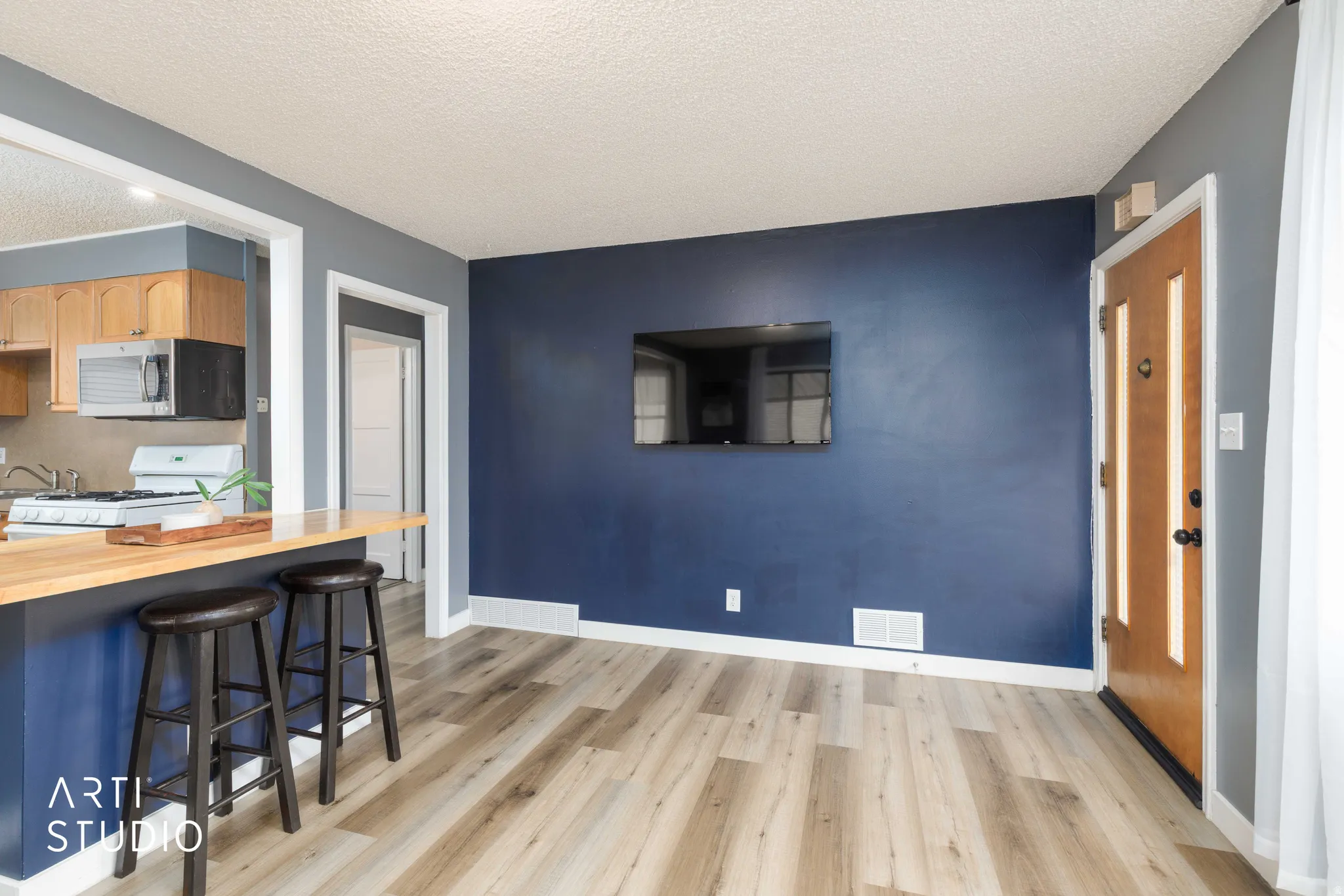 Wood-finish flooring throughout, complemented by a deep blue accent wall