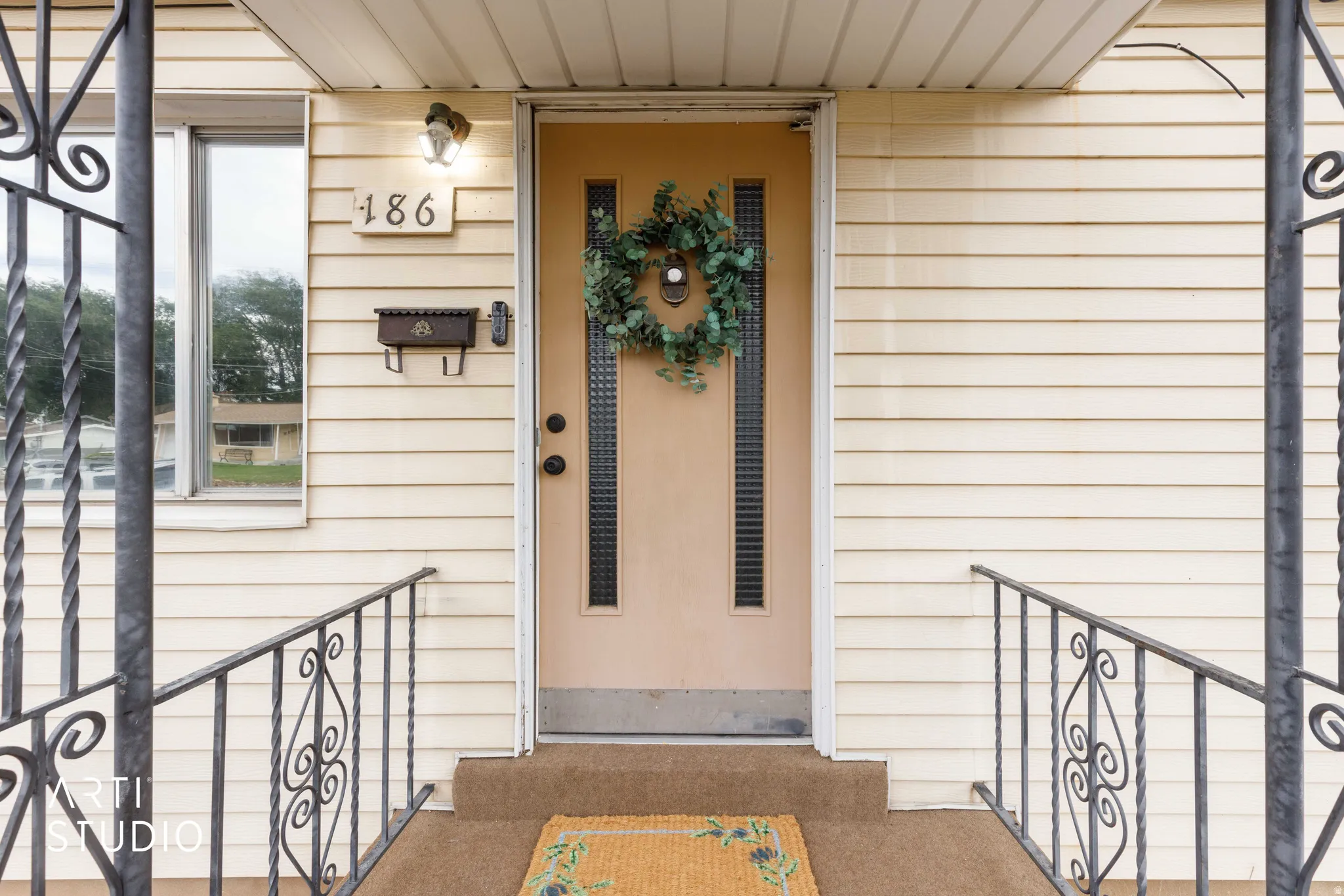 Cream-colored siding facade with a central entry door featuring vertical window inserts