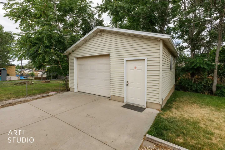 Detached single-car garage featuring horizontal siding and a panel-style door