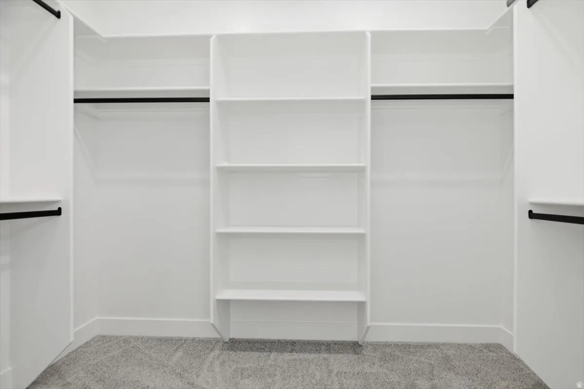 Built-in white shelving system featuring multiple storage compartments and matte black hanging rods