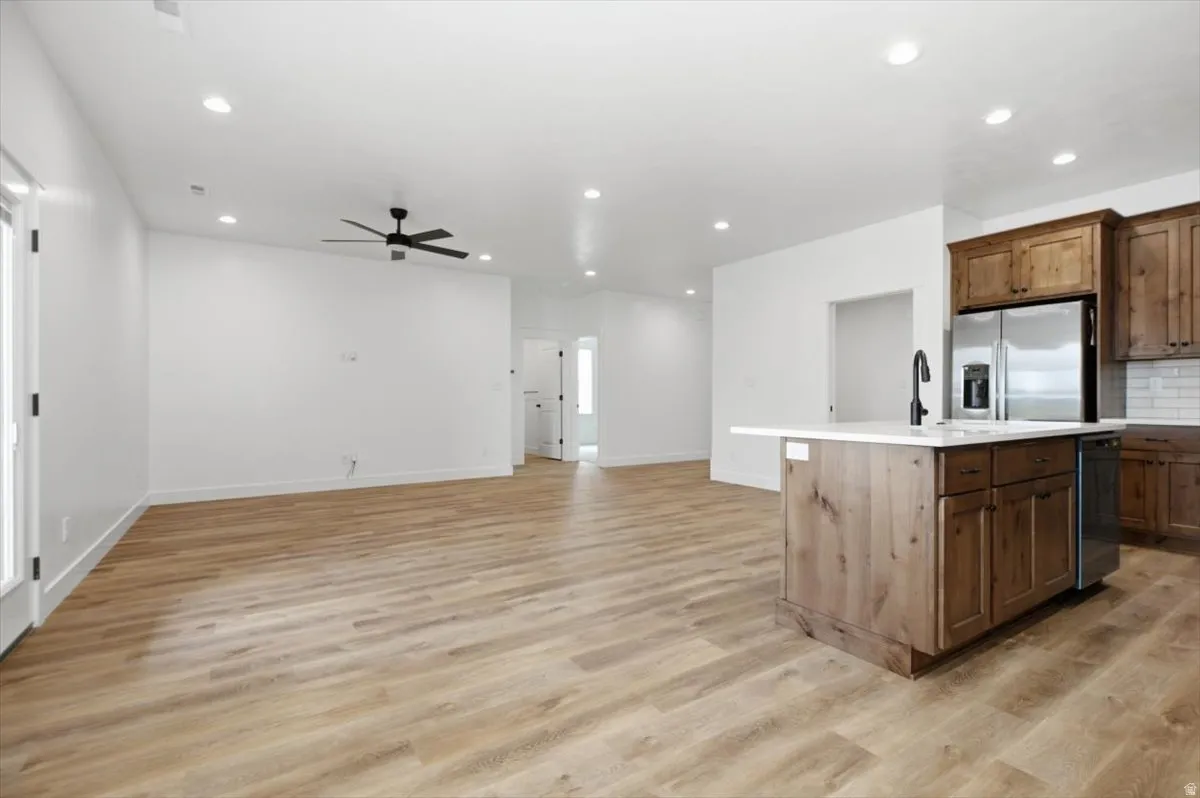 Open-concept living area featuring wood-finish flooring, recessed lighting, and a ceiling fan